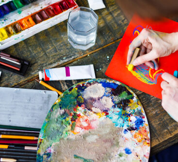 Soiled,Artists,Hands,Is,Painting,On,Orange,Paper,Sheet.,Top